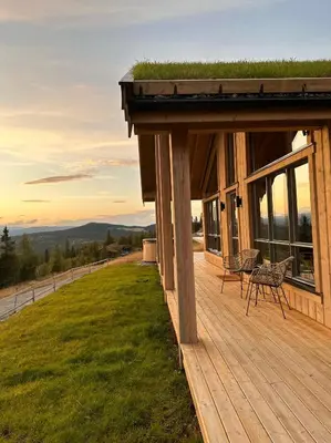 a house with a deck with a grass roof at Snowcake Cottage in Sør-Fron