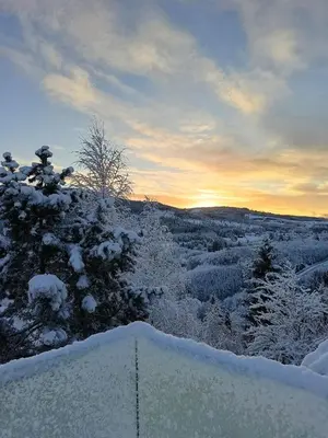 a view of a snow covered field with the sunset at Holiday home in Steinkjer in Steinkjer