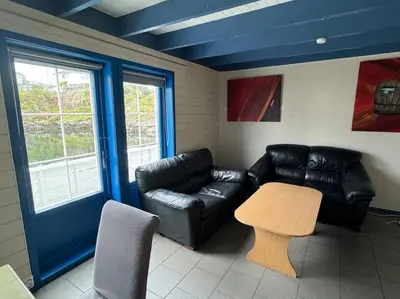 a living room with a leather couch and a table at Nautnes Coastal Haven in Nautnes