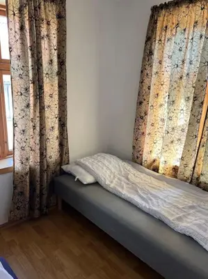 a bed in a room with curtains and a window at Fishermans Apartment A13 in Nautnes
