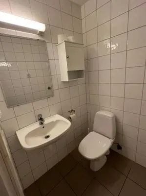 a bathroom with a toilet and a sink at Fishermans Apartment A13 in Nautnes