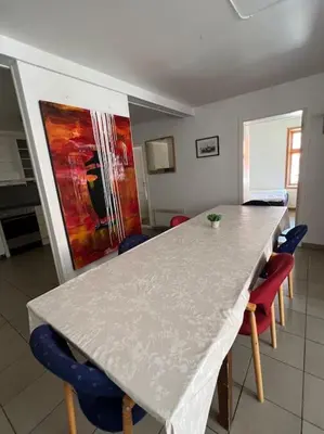 a kitchen with a counter with chairs and a table at Fishermans Apartment A13 in Nautnes