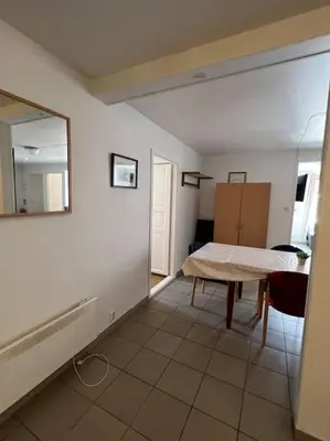 a room with a table and a mirror on the wall at Fishermans Apartment A13 in Nautnes