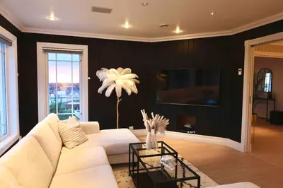 a living room with a white couch and a tv at Villa Freya with stunning sea view in Kristiansund