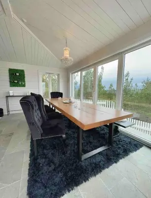 a large dining room with a wooden table and chairs at Villa Freya with stunning sea view in Kristiansund