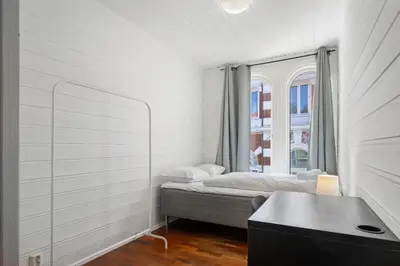 a white room with a bed and a window at City Center Apartment in Bergen
