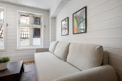 a living room with a couch and two windows at City Center Apartment in Bergen