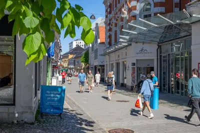 a group of people walking down a street at City Center Apartment in Bergen