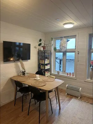 a dining room with a wooden table and chairs at City Center Apartment in Bergen