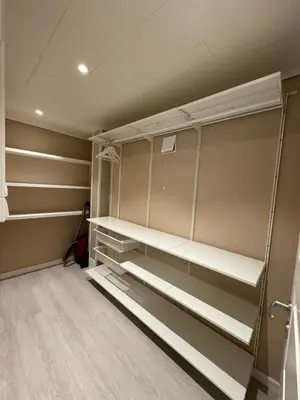 a walk in closet with white shelves at StarView Trolltunga Apartment in Odda