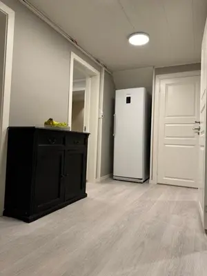 a kitchen with a white refrigerator and a black cabinet at StarView Trolltunga Apartment in Odda