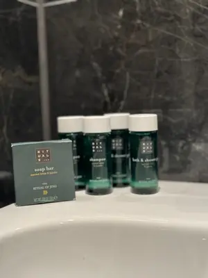 a group of four bottles of soap sitting on a shelf at StarView Trolltunga Apartment in Odda