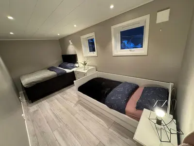 a small bedroom with two beds and a table at StarView Trolltunga Apartment in Odda