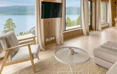 a living room with a couch and a table and a tv at 3 Bedroom Amazing Home In Åfarnes in Åfarnes