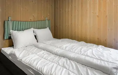 a bed with white pillows and a green headboard at 3 Bedroom Amazing Home In Åfarnes in Åfarnes
