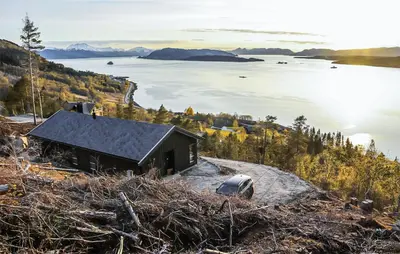 a cabin on the side of a hill overlooking a body of water at 3 Bedroom Amazing Home In Åfarnes in Åfarnes