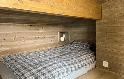 a bed in a room with a wooden wall at Cozy Home In Ålen With Wifi in Ålen