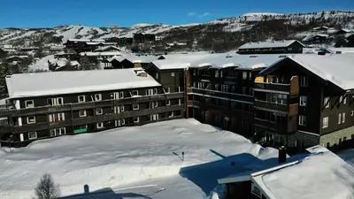 a building covered in snow with snow covered roofs at Enjoy Scenic Views From Your Balcony in Beitostøl