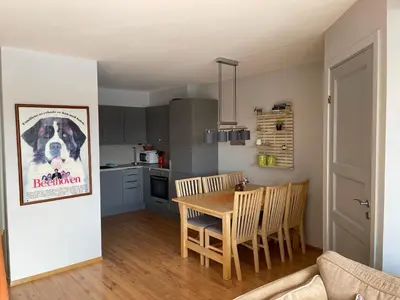 a kitchen and dining room with a dog poster on the wall at Enjoy Scenic Views From Your Balcony in Beitostøl