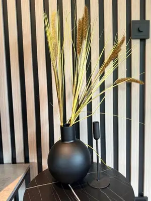 a black vase sitting on a table with a plant at Dalen Apartment in Stranda
