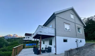 a house with a balcony on top of it at Dalen Apartment in Stranda