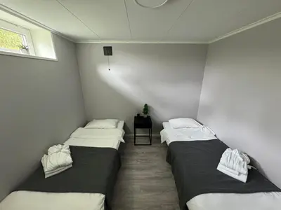 two twin beds in a room with a table at Dalen Apartment in Stranda