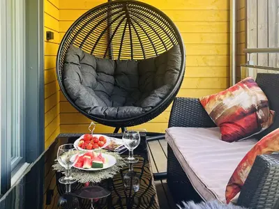 a swing chair on a balcony with a bowl of fruit at 4 person holiday home in Frekhaug in Hordvik