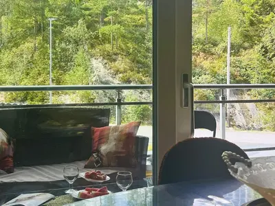 a table with a plate of food and two wine glasses at 4 person holiday home in Frekhaug in Hordvik