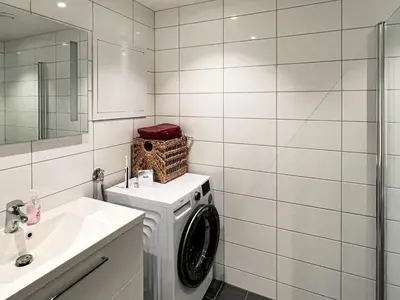 a bathroom with a washing machine and a sink at 4 person holiday home in Frekhaug in Hordvik