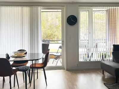 a living room with a table and a clock on the wall at 4 person holiday home in Frekhaug in Hordvik
