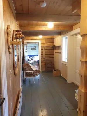 a hallway of a cabin with a room with wooden floors at Newly renovated house on a farm in Berge