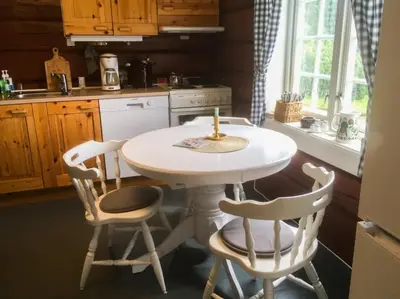 a kitchen with a white table and two chairs at Newly renovated house on a farm in Berge