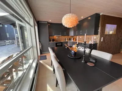 a dining room with a black table and chairs at Geilo Kikut - Ski-in Ski-out in Geilo