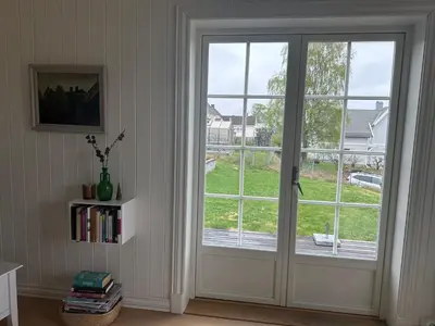 a sliding glass door with a view of a yard at Koselig hus med stor og solrik hage in Lillehammer
