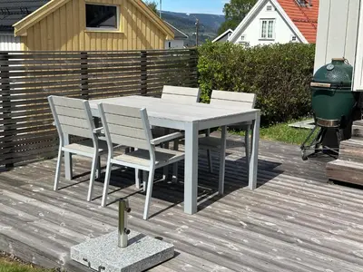 a white table and chairs on a deck at Koselig hus med stor og solrik hage in Lillehammer