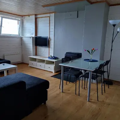 a living room with a table and chairs and a tv at Lillehammer, Gjøvik pâ 2836 Biri apartments in Biri