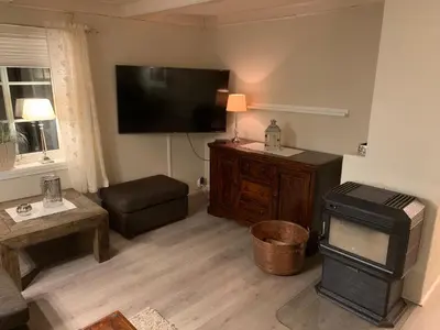 a living room with a flat screen tv and a couch at Rikstaddal in Kalvhagen