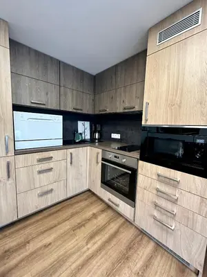 a large kitchen with wooden cabinets and appliances at Vika Minihouse in Kristiansund