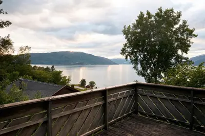 a view of a lake from a wooden fence at Fjordhytte-1 ist eine schöne Hütte bei Ænes am Hardangerfjord mit grandiosem Fjordpanorama, 20 PS Motorboot mietbar in Ænes