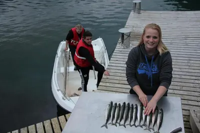 a group of people on a dock with a bunch of fish at Fjordhytte-4 nahe Trolltunga, Hardanger, direkt am Maurangerfjord in besonders attraktiver Umgebung in Sundal