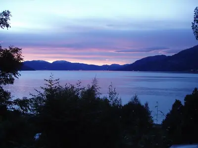 a view of a large body of water at sunset at Fjordhytte-2 am Hardangerfjord, grandioses Fjordpanorama, 20 PS Motorboot mietbar! in Ænes