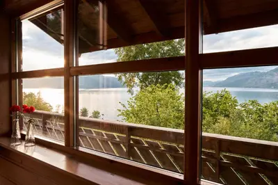 a window with a view of a lake and mountains at Fjordhytte-2 am Hardangerfjord, grandioses Fjordpanorama, 20 PS Motorboot mietbar! in Ænes