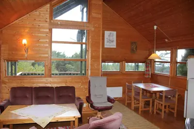 a living room with a couch and a table at Fjordhytte-41 mit mietbarem 9,9 PS Motorboot am Hardangerfjord in Rosendal