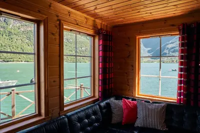a couch in a room with three windows at Fjordhytte-5 Hardanger-Region, zwischen Odda und Rosendal in Sundal