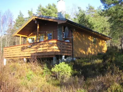 a wooden cabin on a hill in the woods at Fjordhytte-39 am Hardangerfjord, Motorboot mietbar in Rosendal
