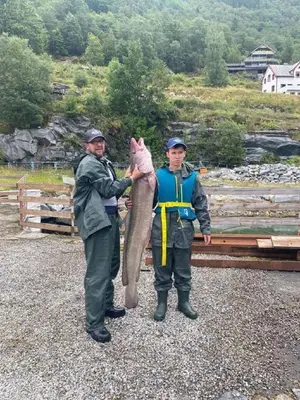 two men holding a large fish in their hands at Fjordhytte-16 direkt am Sognefjord in Bjordal, mit mietbaren 9,9 PS bis 60 PS Motorbooten in Bjordal