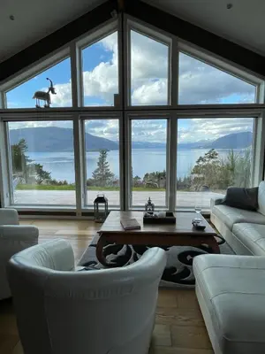 a living room with a large window with a table and chairs at Fjordhytte-13 in Ænes
