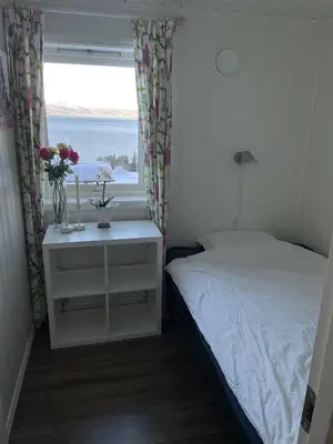 a small bedroom with a bed and a window at Fjordhytte-13 in Ænes