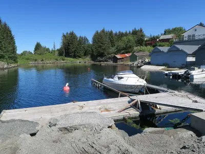 a boat is docked at a dock in the water at Fjordhytte-36 in Bøvågen