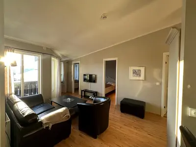 a living room with a couch and a table at Charming Top Floor Apartment With Balcony in Beitostøl